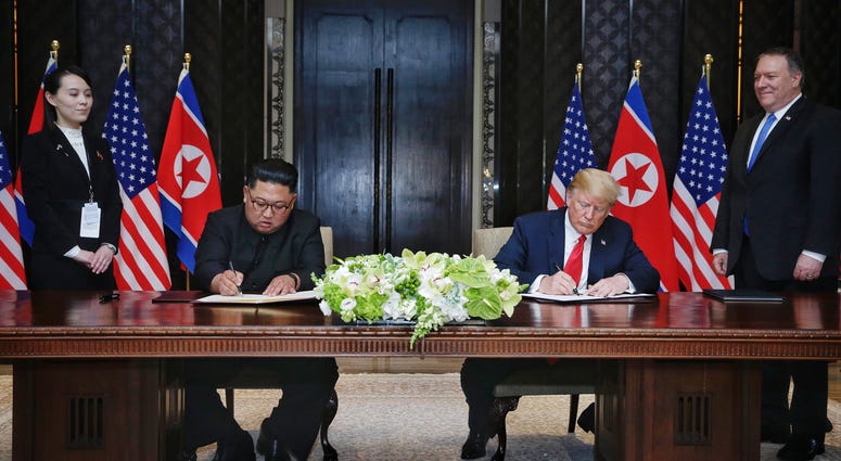 eader of the Democratic People's Republic of Korea (DPRK) Kim Jong Un (2nd L) and U.S. President Donald Trump (2nd R) sign a joint statement in Singapore on June 12, 2018.
