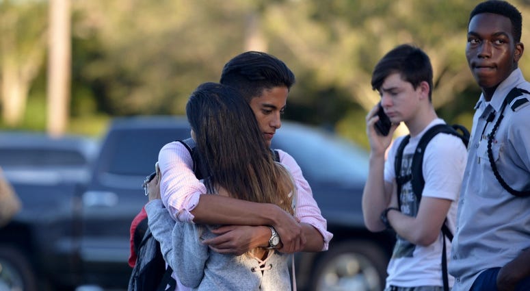 Jorge Zapata,16, a student at Marjory Stoneman Douglas High School in Parkland, embraces his mother, Lavinia Zapata, after a mass shooting earlier in the day at the school.