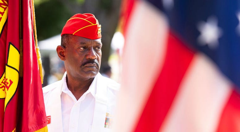 Tom Capers holds the Marine Corps flag with the color guard before the start of the City of Port St. Lucie, Florida Memorial Day Service. Memorial Day weekend across America.