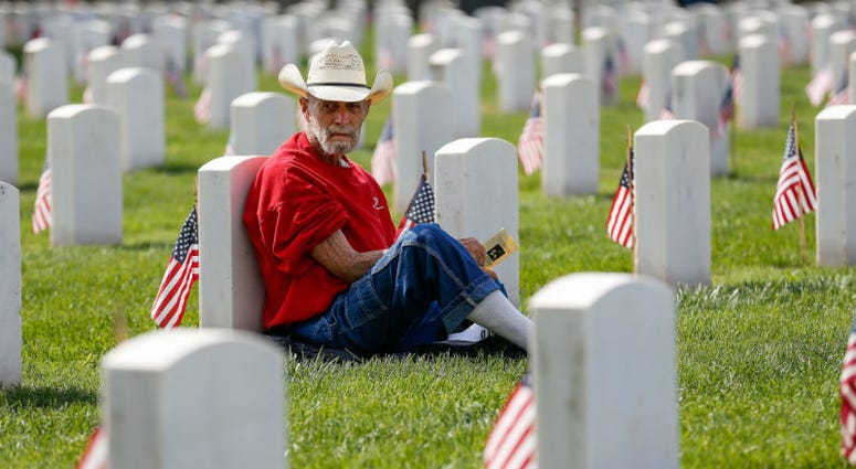 Ed Zellers rests against a headstone before the start of a Memorial Day ceremony at the Springfield National Cemetery. Memorial Day weekend across America.