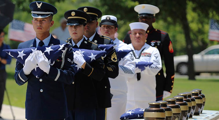 In this Friday, June 1, 2018 photo, military service members with the Armed Services Honor Guard prepare to present folded flags as Fort Sam Houston National Cemetery and the Missing In America Project conduct a military burial service.
