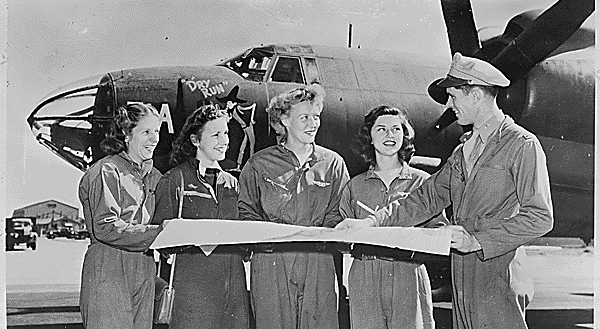 Four members of the United States Women's Airforce Service Pilots (WASPs) receive final instructions as they chart a cross-country course on the flight line of U.S. airport. Four members of the United States Women's Airforce Service Pilots