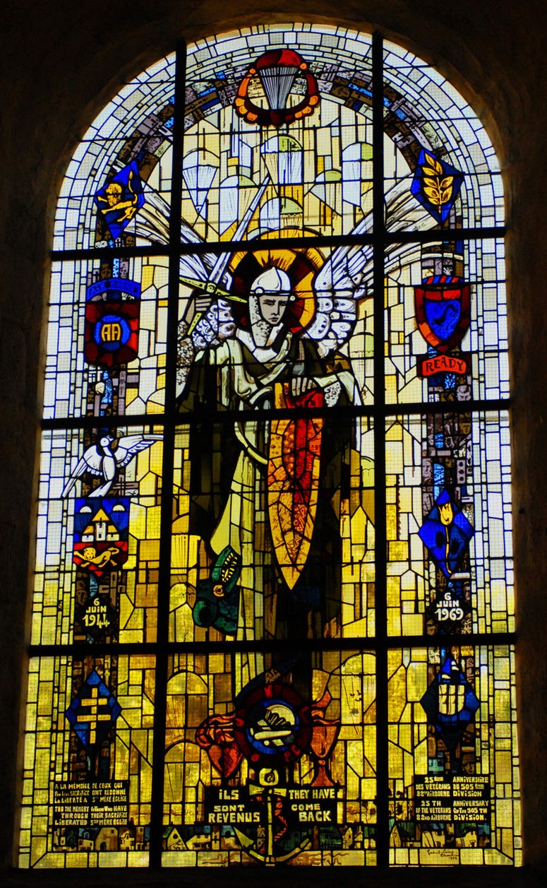 The window depicts Saint Michael, the patron saint of paratroopers, and also bears images symbolizing the 82nd Airborne Division, the lion of Normandy, and Sainte Mere Eglise.