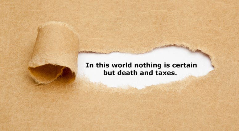 Quote In this world nothing is certain but death and taxes, appearing behind ripped brown paper.
