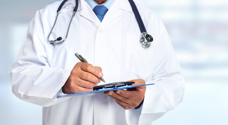 Doctor in white coat holding clipboard