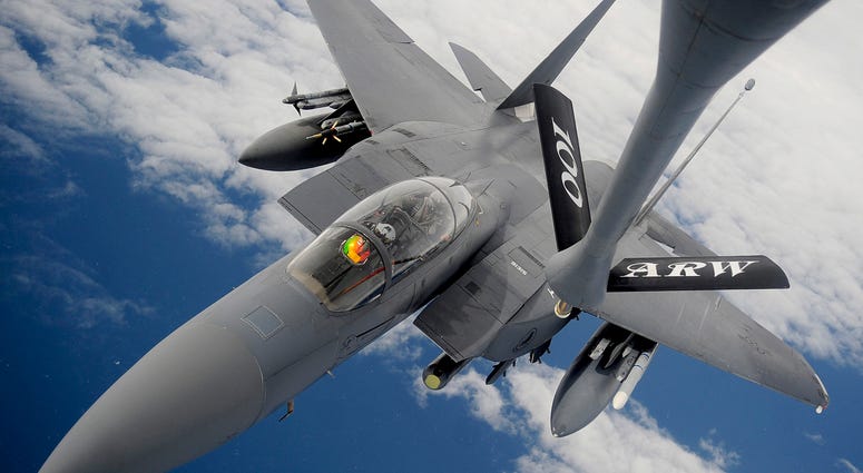 An F-15E Strike Eagle receives fuel from a 100th Air Refueling Wing KC-135 Stratotanker during an aerial refueling mission over the Atlantic Ocean.