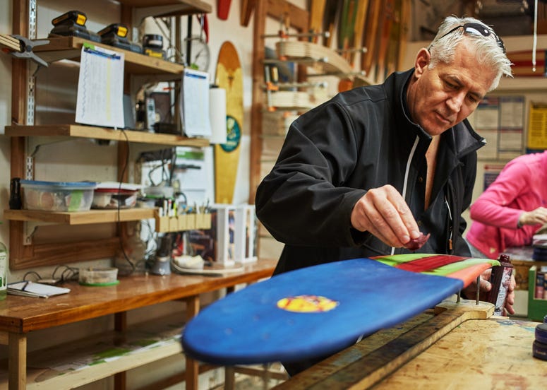 Maloney and the KOTA Longboards team make each board by hand Mike Maloney Navy fighter pilot founder of KOTA Longboards shapes a board