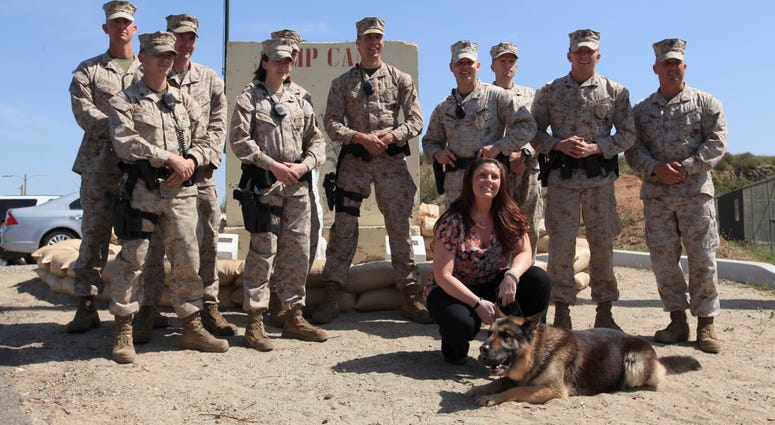 Camp Pendleton dog handlers and Former Cpl. Megan Leavey pose with Military Working Dog Rex during his retirement ceremony and adoption at the base's K-9 unit.