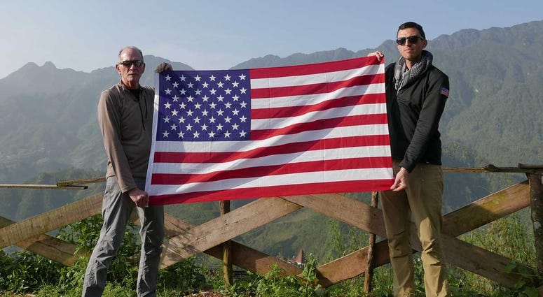 Rich Rice (left) and Jason McCarthy (right) pose with an American flag in Vietnam