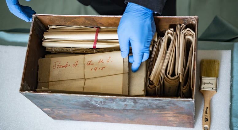 Tim Frank, historian, History Office; reaches into the newly opened Memorial Amphitheater memorabilia box