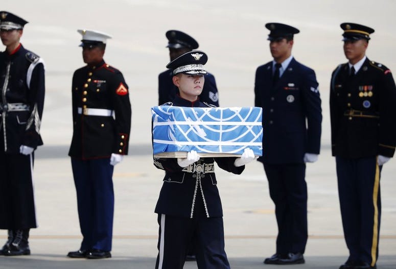 A solider carries a casket carrying what are believed to be the remains of an American service member killed during the Korean War.