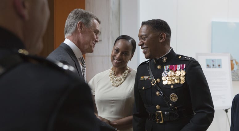 U.S. Senator David A. Perdue, (GA), left, speaks with U.S. Marine Corps Maj. Gen. Craig C. Crenshaw, commanding general, Marine Corps Logistics Command, right, during a sunset parade reception at the Women in Military Service for America Memorial