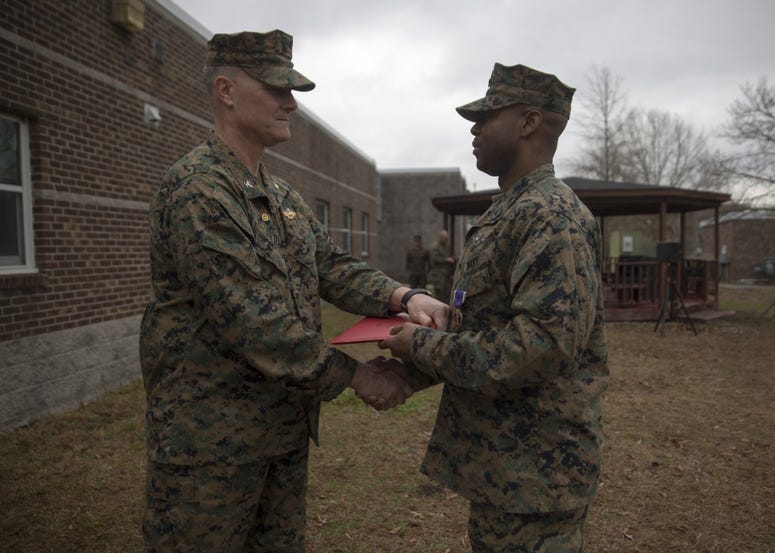 Capt. Brian Tolbert, the commanding officer of 2nd Medical Battalion, 2nd Marine Logistics Group, awards Petty Officer 2nd Class Willie Jones, a corpsman with 2nd Med. Bn., a Purple Heart during an award ceremony at Camp Lejeune N.C., Feb. 8, 2018.