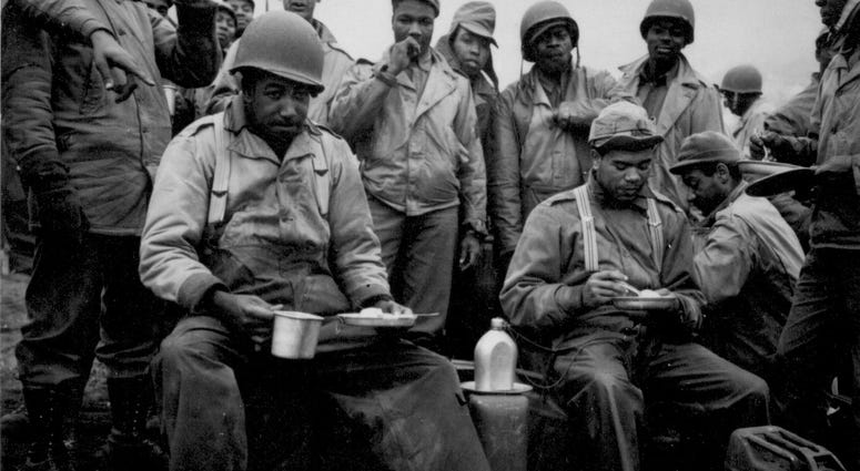 3. A kitchen was set up along the beach for the...labor battalion unloading the boats. This picture shows a couple of the men enjoying a hot meal for a change. Massacre Bay, Attu, Aleutian Islands in 1943.