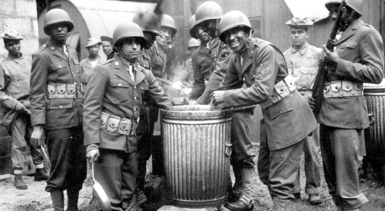 In 1942, 4. Negro soldiers draw rations at the camp cook house at their station in Northern Ireland. Detachments of Negro troops were among the latest arrivals with the American forces in Northern Ireland