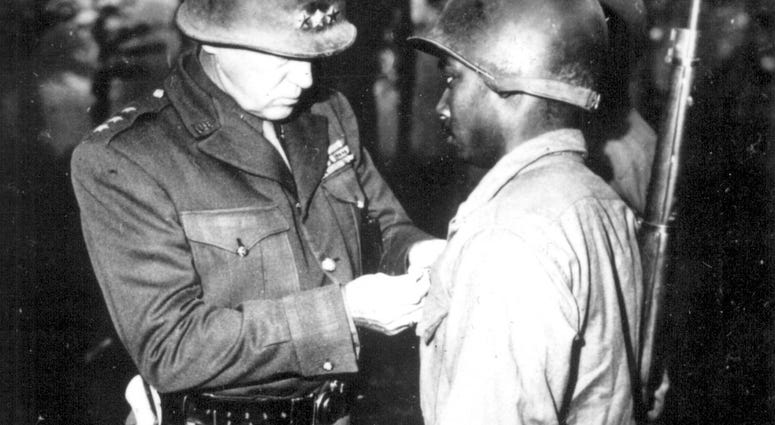 7. Lt. Gen. George S. Patton, U.S. Third Army commander, pins the Silver Star on Private Ernest A. Jenkins of New York City for his conspicuous gallantry in the liberation of Chateaudun, France. October 13, 1944