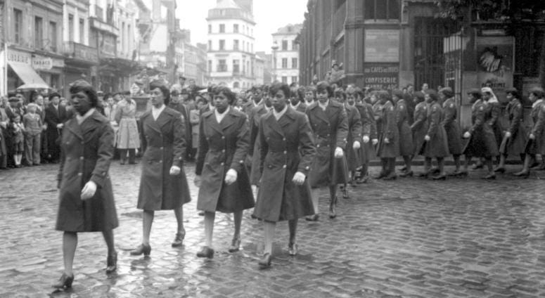 Members of the 6888th Central Postal Directory Battalion take part in a parade ceremony in honor of Joan d'Arc at the marketplace where she was burned at the stake. May 27, 1945