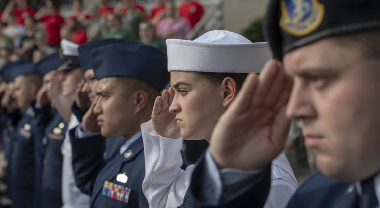 Service members salute during a ceremony for Memorial Day at Yokota Air Base, Japan, May 25, 2018. The 374th Airlift Wing hosted the ceremony in memory of those who made the ultimate sacrifice during military service.