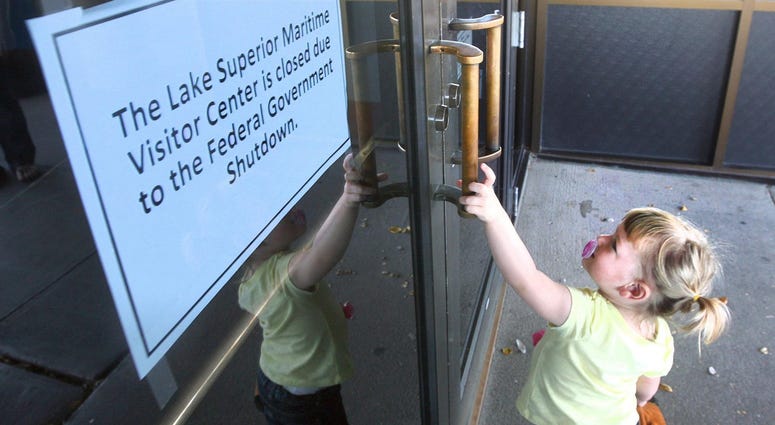 Healthcare programs for children and the elderly are ok for now, but money will run out by March for many programs. Madison Meyenburg, 2, of Elk River, Minnesota, attempts to open the door at Lake Superior Maritime Visitor Center in Canal Park.