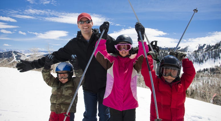 A happy father and his kids on a ski resort vacation in Park City, Utah skiing