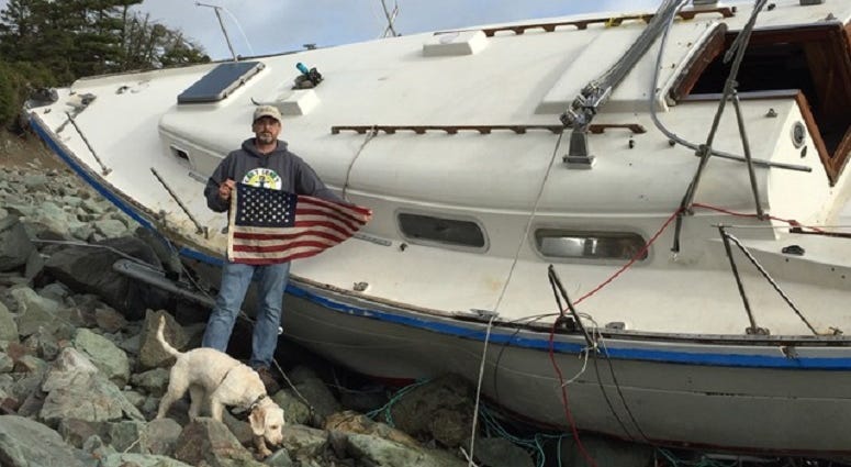 Steve Smith with an American flag recovered from Liberty, a sailboat wrecked on Cape Breton Island, Canada