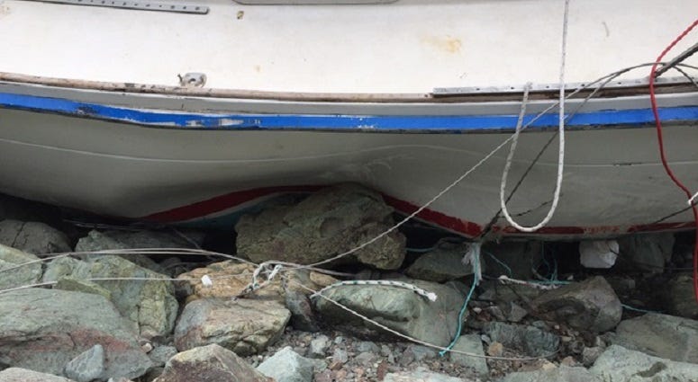 Severe damage is visible on the hull of Liberty, a sailboat wrecked on Cape Breton Island, Canada