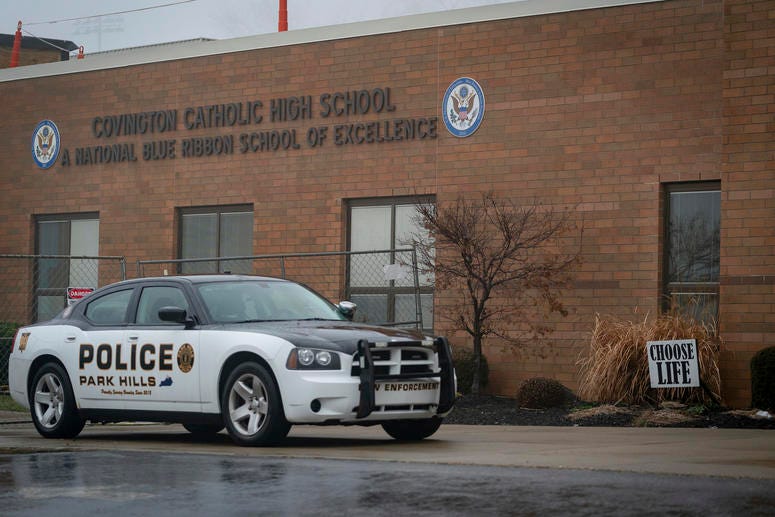 A police car sits in front of Covington Catholic High School in Park Hills, Ky., Saturday, Jan 19, 2019. A diocese in Kentucky apologized Saturday after videos emerged showing students from the Catholic boys' high school mocking Native Americans outside t