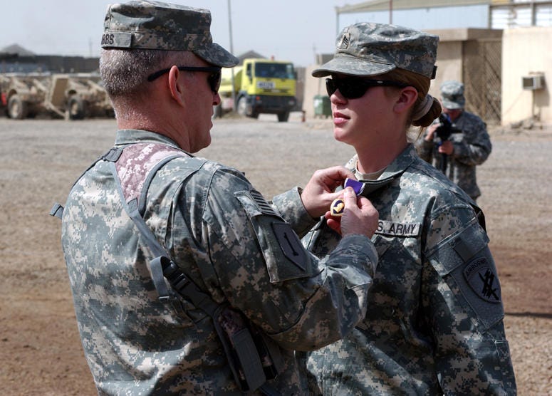 Col. Ricky Gibbs, commander, 4th Brigade Combat Team, 1st Infantry Division, Multi-National Division - Baghdad, places a Purple Heart on the collar of Sgt. Jennifer Hunt, a civil affairs specialist assigned to Company A, 450th Civil Affairs Battalion (Air