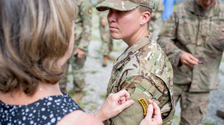 A family member places the Army Ranger tab on Staff Sgt. Amanda Kelley's uniform. AmandaKelley
