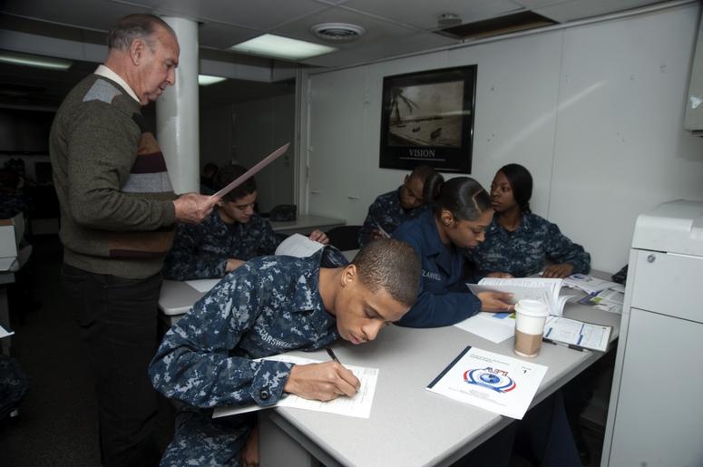 Yeoman Seaman Rhondal Carswell works on math problems during the first day of the Navy College Program for Afloat College Education (NCPACE) academic skills math course aboard the aircraft carrier USS Harry S. Truman (CVN 75). NCPACE