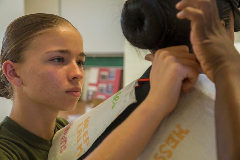 Rct. Katrina L. Savoy, Platoon 4039, Oscar Company, 4th Recruit Training Battalion, ensures a fellow recruit’s hair is presentable for her first official Marine Corps photo Oct. 23, 2015, on Parris Island, S.C.