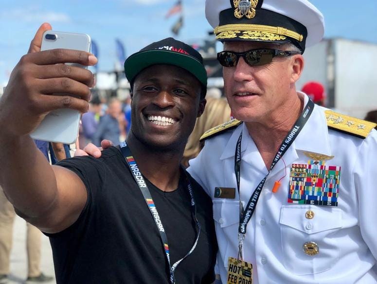 Navy Lt. and NASCAR driver Jesse Iwuji takes a photo with a Navy admiral. NASCAR driver and Lt. in the Navy Reserves Jesse Iwuji