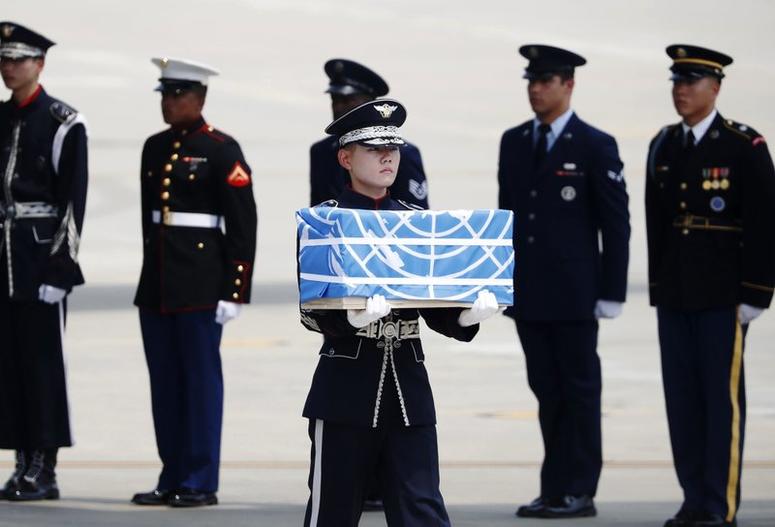 A solider carries a casket carrying what are believed to be the remains of an American service member killed during the Korean War.