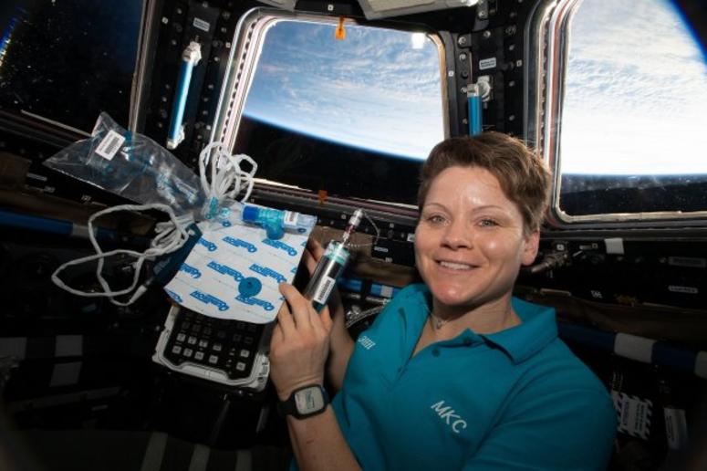 Astronaut Lt. Col. Anne McClain is pictured in the cupola holding biomedical gear for an experiment that measures fat changes in the bone marrow before and after exposure to microgravity. Army astronaut reflects on mission 250 miles above Earth