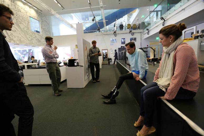 The MIT Biomechatronic team and VA Innovation Coordinator observe Lead Investigator, Dr. Hugh Herr, demonstrate the full prosthetic socket system created by the team. VA Innovation Ecosystem members observe a demonstration of a new type of prosthetic leg sockets at MIT