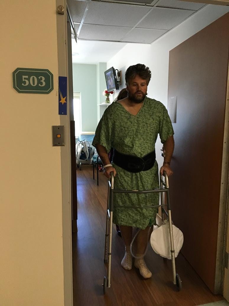 Brian Tally walking with assistance from a walker.