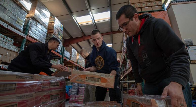 Sailors assigned to Naval Base Kitsap-Bangor and Trident Training Facility organize pallets at the Central Kitsap Food Bank in Silverdale, Wash. FoodBank