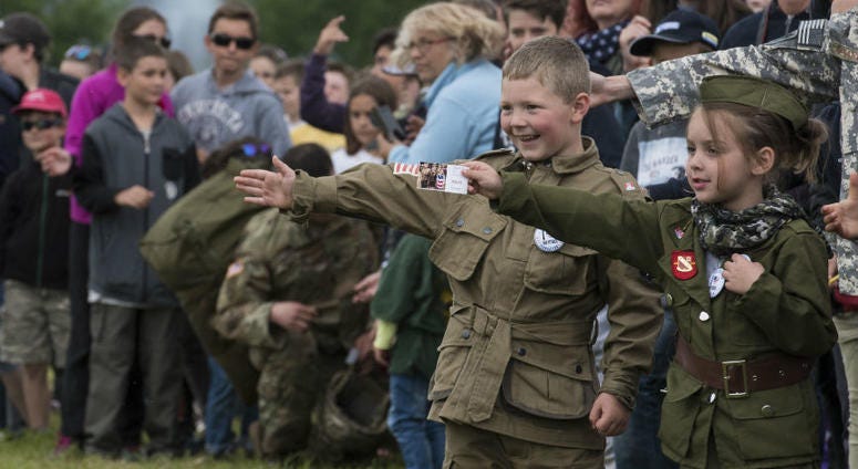 A French boy, dressed in a mock WWII-era uniform displaying the American flag, Canadian flag and an illustrated pin stating “I heart our veterans." Over 1,000 U.S. paratroopers participate in largest airborne operation since WWII to commemorate 75th anniversary of D-Day.