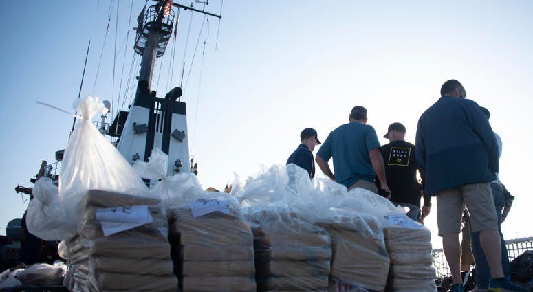 Coast Guardsmen prepare bails of cocaine to be offloaded