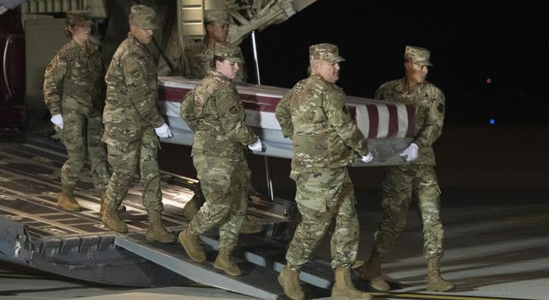 An Air Force carry team moves a transfer case containing the remains of Navy Ensign Joshua Watson