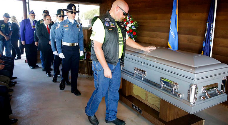 A mourner touches the casket of World War II veteran Herman White