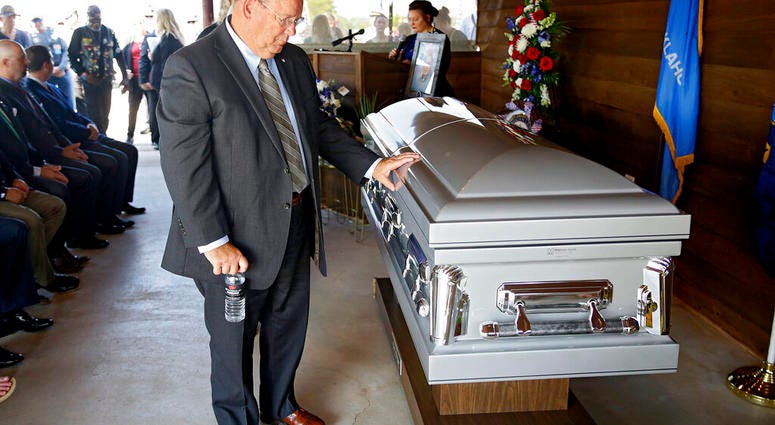 Ben Robinson, Oklahoma Secretary of MIlitary and Veterans Affairs, touches the casket of World War II veteran Herman White