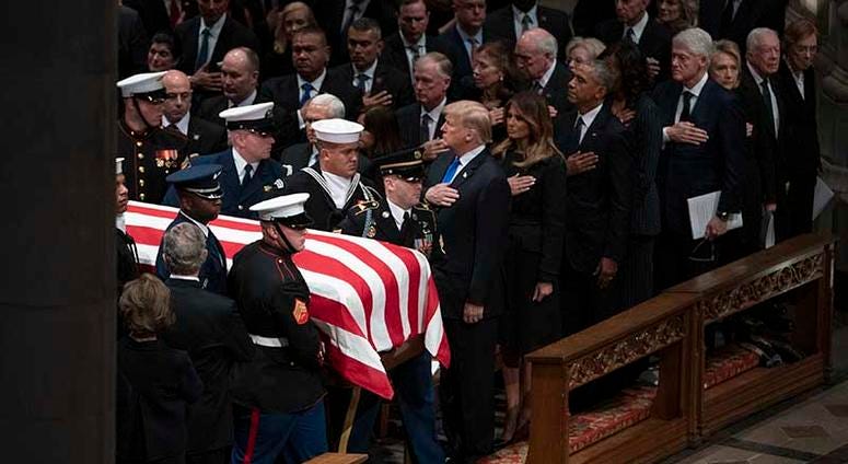 The flag-draped casket of former President George H.W. Bush is carried by a military honor guard past former President George W. Bush and wife Laura Bush, President Donald Trump, first lady Melania Trump, former President Barack Obama, Michelle Obama, for
