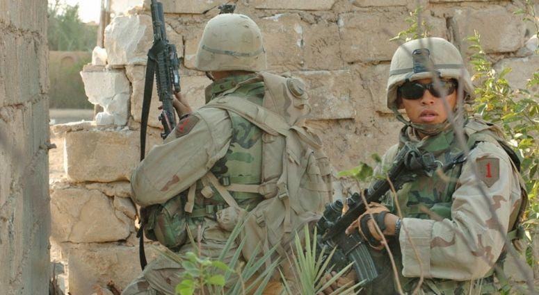 SPC Jacob J. Hill (L) from Cincinnati, Ohio and PFC David L. Gillette from St. Slidell, Louisiana, search houses in southeast Fallujah Nov. 15 during Operation Al-Fajr. Soldiers from 1st Infantry Division, 3rd Brigade Reconnaissance Troop fight insurgents in Fallujah Iraq, Nov 2004