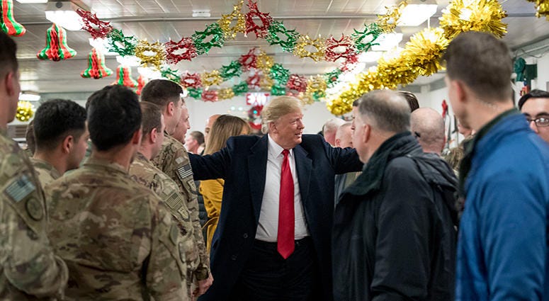 President Donald Trump visits with members of the military at a dining hall at Al Asad Air Base, Iraq, Wednesday, Dec. 26, 2018.