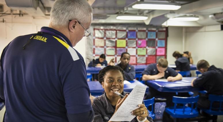 Sailors take exams for a Navy College Program for Afloat College Education (NCPACE) course aboard the amphibious dock landing ship USS Fort McHenry (LSD 43) in the Gulf of Oman in 2015. NCPACE