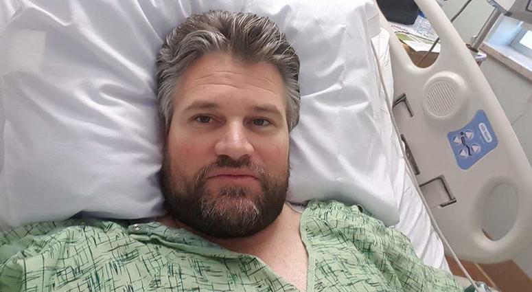 Marine Corps veteran Brian Tally lays in a hospital bed with a debilitating back injury.