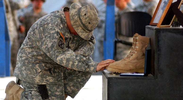 A Soldier pays his respects to Staff Sgt. Travis Atkins, who was killed June 1 by a suicide bomber near Sadr Al-Yusufiyah, Iraq, at a memorial ceremony held June 7 at Camp Striker. Atkins was on a patrol with his unit, Company D, 2nd Battalion, 14th Infan Staff Sgt. Travis Atkins will recieve the Medal of Honor
