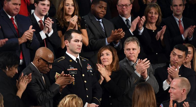 Staff Sgt. Justin Peck stands as he is acknowledged by President Donald Trump during the State of the Union address from the House chamber of the United States Capitol.