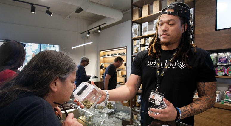 Kerry Durrell, 61, inspects marijuana held by "budtender" Pierce Hunter at Urbn Leaf in San Diego, Calif. dispensary